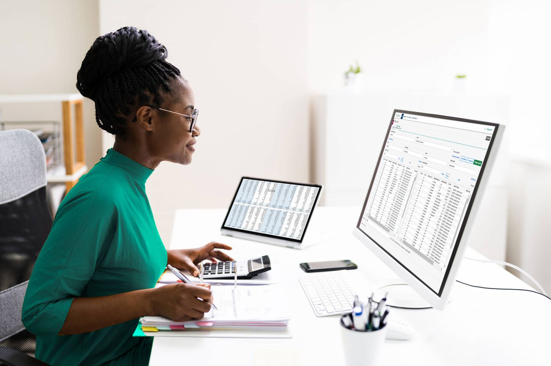 Lady sitting at desk working on computer with a screenshot of Trintech's financial close and financial management software