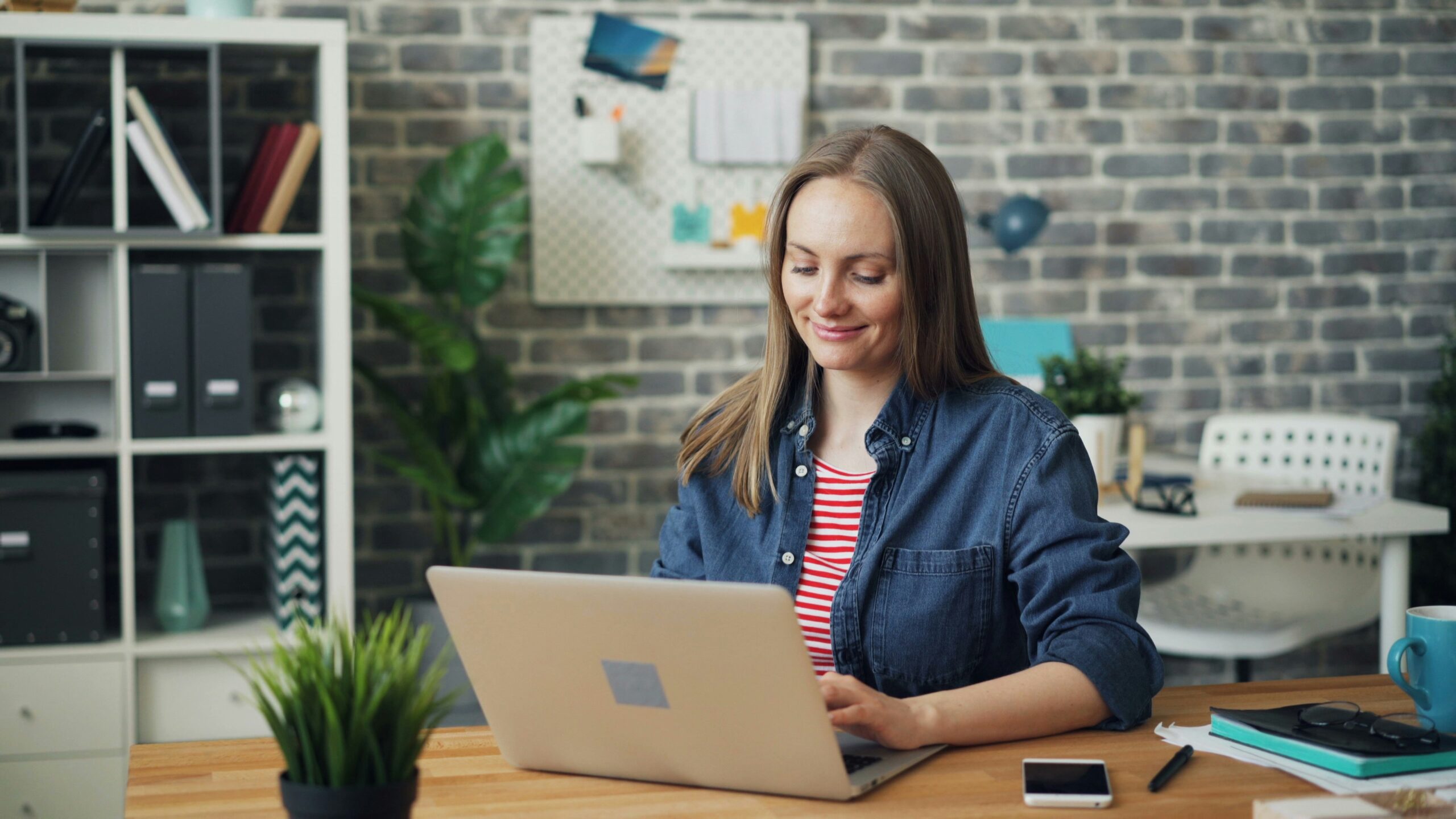 Woman looking at a laptop computer researching financial reconciliation with Cadency.